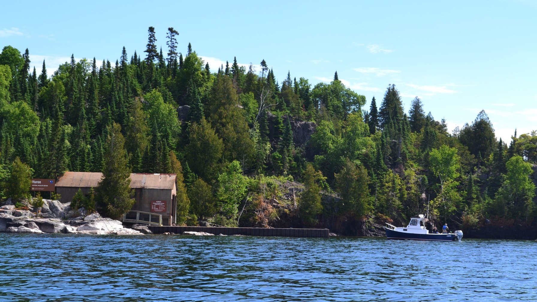 How to register a boat in Michigan: a boat approaching the Lake Huron shoreline at the Huron Islands