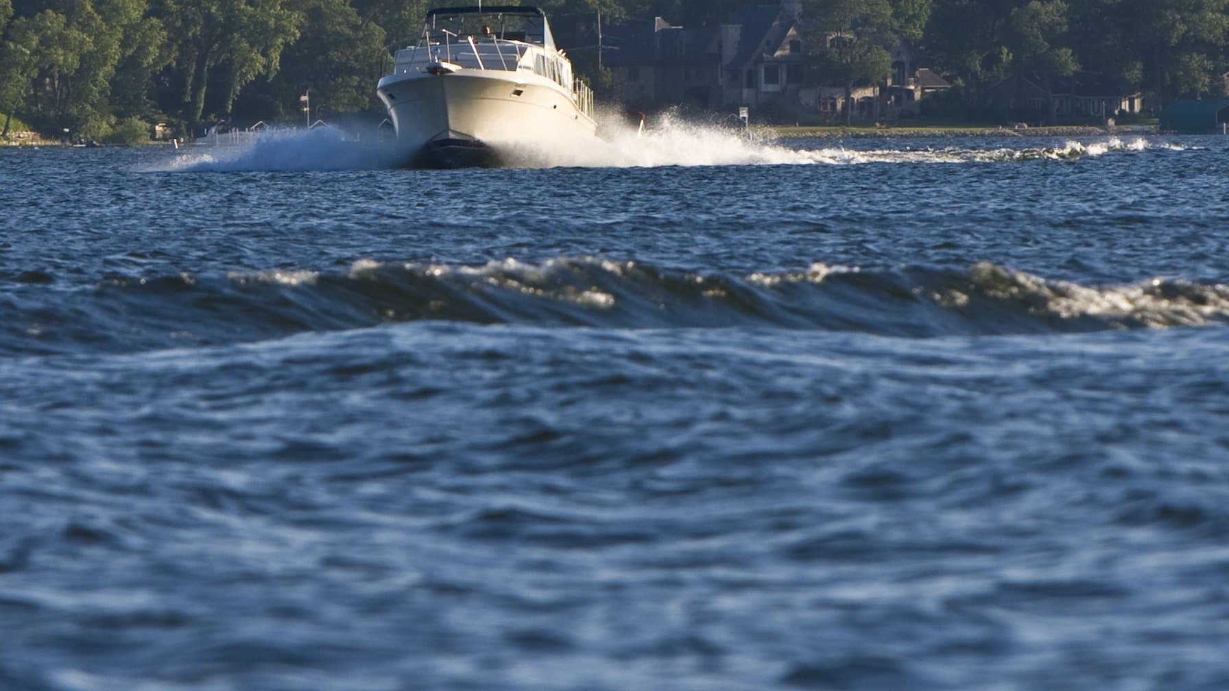 How to register a boat in Minnesota: a cabin cruiser underway on Lake Minnetonka